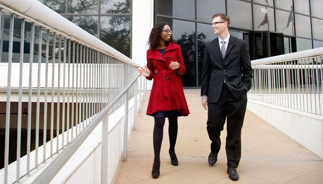 Two employees in professional attire leave SCI headquarters.